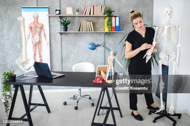 vrolijke vrouwelijke leraar die een anatomieklasse op plastic skelet leidt - course de skeleton stockfoto's en -beelden