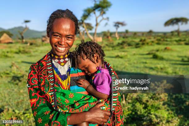 vrouw van de stam van borana die haar baby, ethiopië, afrika houdt - ethiopische etniciteit stockfoto's en -beelden