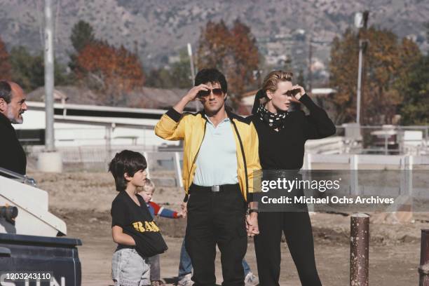 American actor Sylvester Stallone with his wife, Danish actress Brigitte Nielsen, circa 1986. The boy next to them is wearing a 'Rambo' t-shirt.