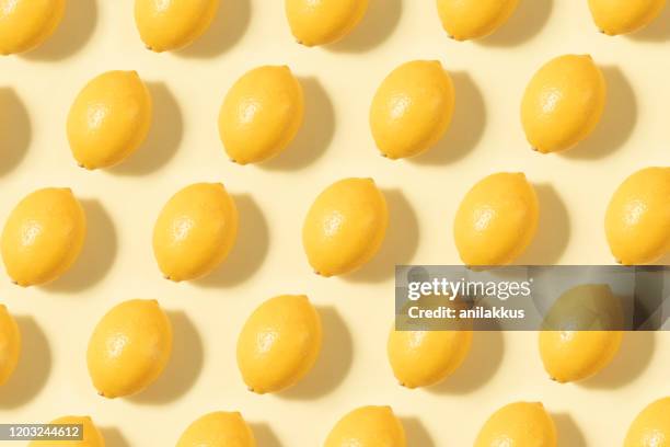 citrons dans une ligne sur le fond jaune - lemon pattern photos et images de collection