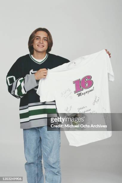 American actor Will Friedle holding a '16' magazine t-shirt autographed by himself, Ashley Johnson, Justin Berfield, Nikki Cox and others, 1995.