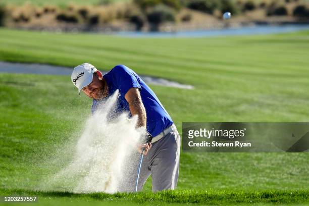 Holmes plays a shot from a bunker on the 18th hole during the second round of the Waste Management Phoenix Open at TPC Scottsdale on January 31, 2020...