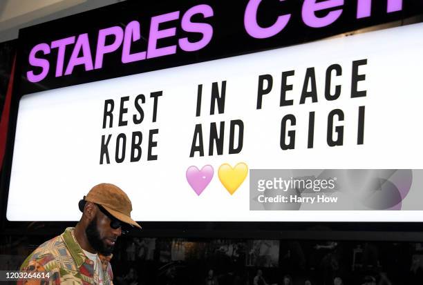 LeBron James of the Los Angeles Lakers arrives for the game against the Portland Trail Blazers as he passes a sign to honor Kobe and Gigi Bryant at...