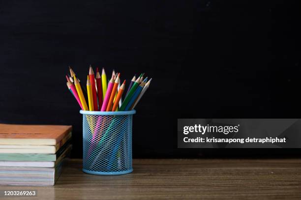 back to school supplies. books and blackboard on wooden background - pen mockup stock-fotos und bilder