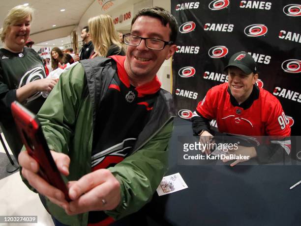 An unidentified fan takes a selfie during an autograph session with David Ayres prior to an NHL game against the Carolina Hurricanes and the Dallas...