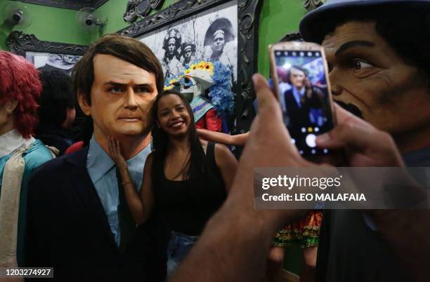 Woman poses next to giant puppet representing Brazilian President Jair Bolsonaro during a traditional carnival parade through the streets of Recife...