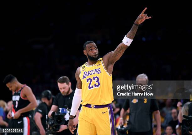 LeBron James of the Los Angeles Lakers points at the two retired jerseys in the rafters to honor Kobe Bryant before the game against the Portland...
