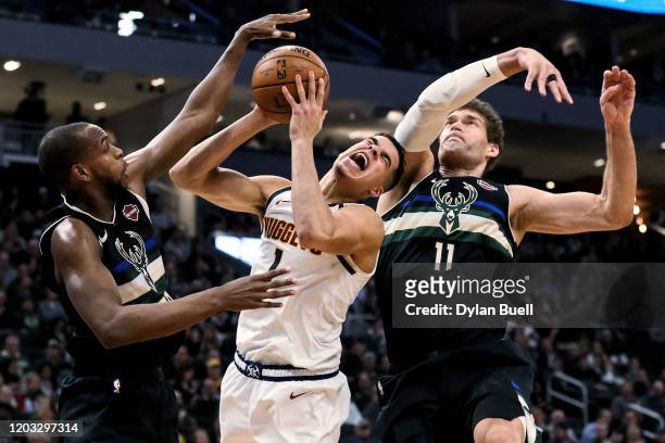 Michael Porter Jr. #1 of the Denver Nuggets attempts a shot while being guarded by Khris Middleton and Brook Lopez of the Milwaukee Bucks in the...