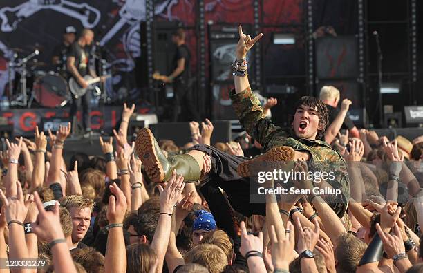 Heavy metal music fans hold aloft a fellow fan during a performance by thrash band Frei.Wild on the first day of the Wacken Open Air heavy metal...