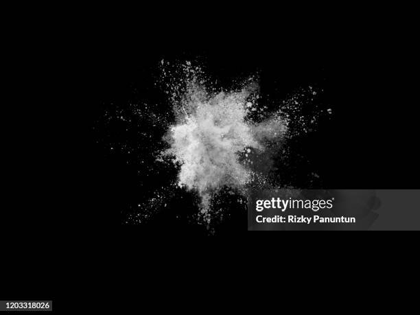 close-up of white powder splashing against black background - black powder stock-fotos und bilder