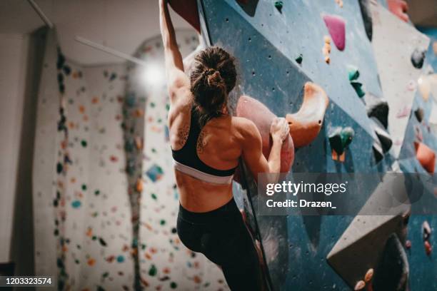 muscular woman on boulder climbing training - bouldering stock pictures, royalty-free photos & images