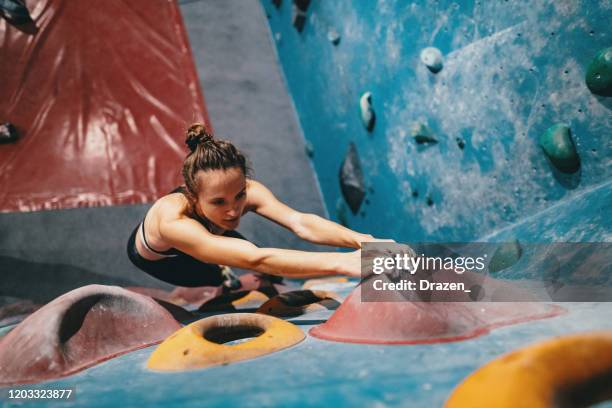 muskuläre frau beim boulder-klettertraining - klettern stock-fotos und bilder