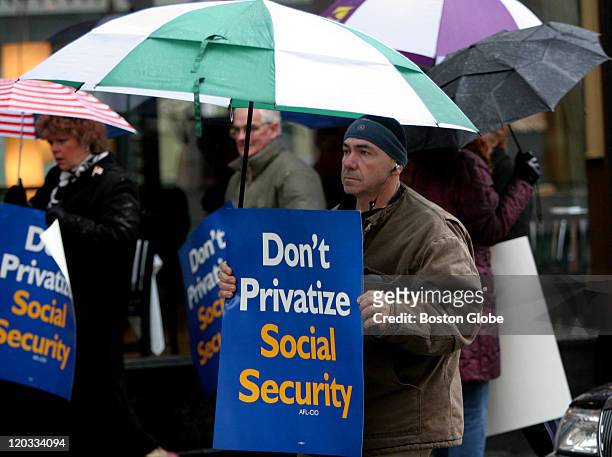 Tony Hernandez of Chelsea protested with others outside of 85 Merrimac Street, regarding privatizing social security and Mitt Romney's stand on it,...