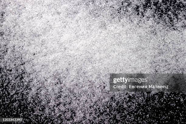abstract wallpaper design of white color shiny snow dust powder isolated on black background - powder snow stock pictures, royalty-free photos & images