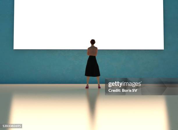 businesswoman watching large monitor - giant woman ストックフォトと画像
