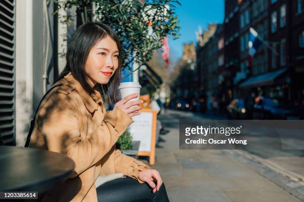 young beautiful woman drinking coffee at outdoor cafe - enjoying coffee cafe morning light stock pictures, royalty-free photos & images