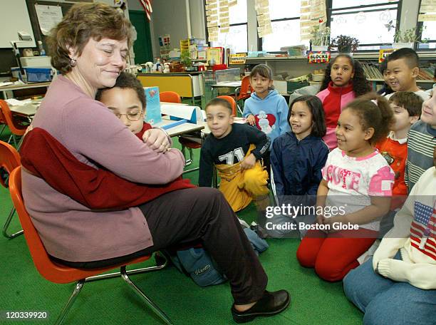 Student Dajan Gilmore gives a goodbye hug to Lori Lentini, Literacy Coordinator at the Drewicz Elementary School in Lynn, who stopped by Marijean...