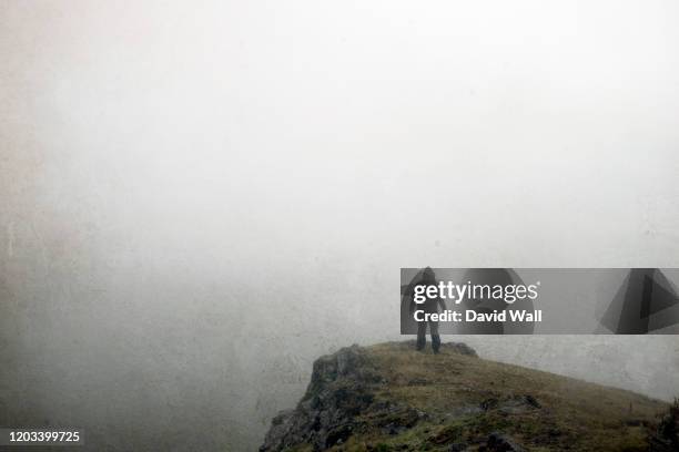 a hiker standing on top of a cliff on a hill. with copy space. with a digital, painted effect and grunge, textured edit. - gothic horror stock pictures, royalty-free photos & images