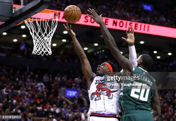 Terence Davis II of the Toronto Raptors shoots the ball as Marvin Williams of the Milwaukee Bucks defends during the second half of an NBA game at...
