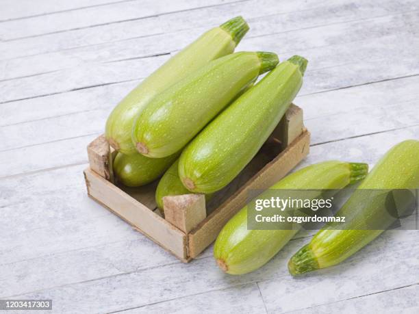 courgettein houten doos op een rustieke houten achtergrond - mergpompoen stockfoto's en -beelden