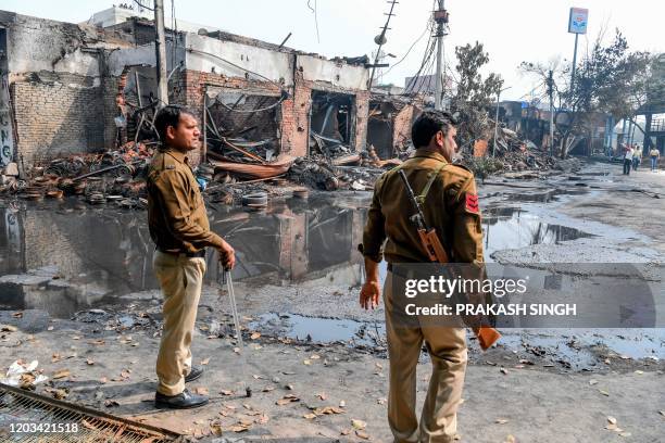 Security personnel patrol near burnt-out tyre market premises following clashes between people supporting and opposing a contentious amendment to...