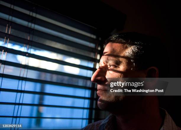 Keith Gartenlaub peers through blinds in the living room of his home in Southern California on Wednesday March 23rd. Gartenlaub has been charged with...