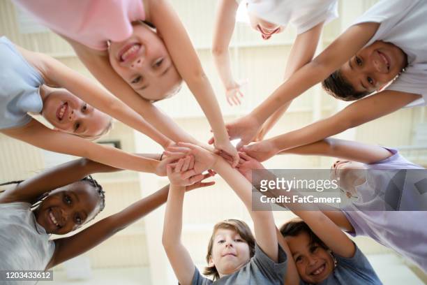 multi- ethnic elementary kids team cheer stock photo - kid cheering stock pictures, royalty-free photos & images