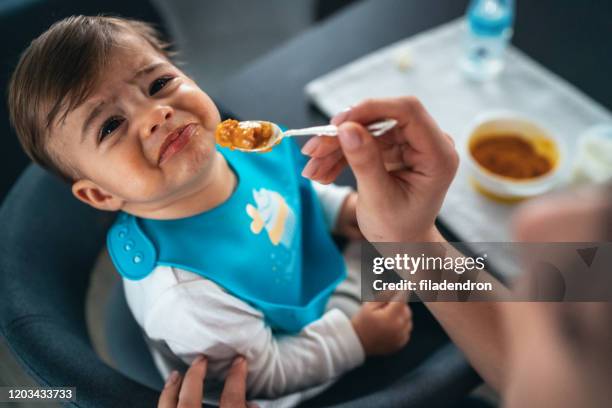 der versuch, einen kleinen jungen zu füttern - ablehnen stock-fotos und bilder