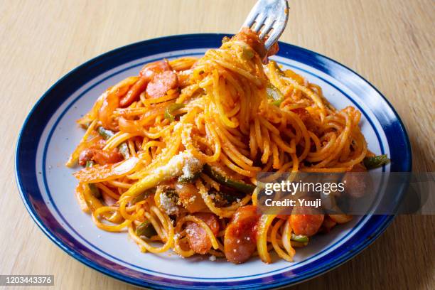 japanese pasta dish, spaghetti (naporitan) recipe. naporitan on a plate is placed on a light wood grain table. spaghetti with fork entangled. - spaghetti imagens e fotografias de stock