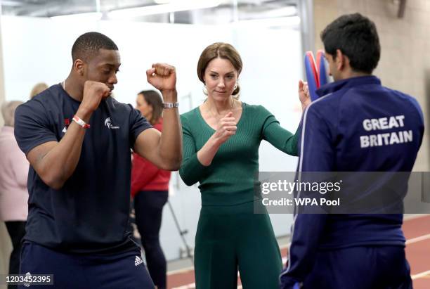 Catherine, Duchess of Cambridge is shown Taekwondo moves by Great Britain's Lutalo Muhammad during a SportsAid Stars event at the London Stadium in...