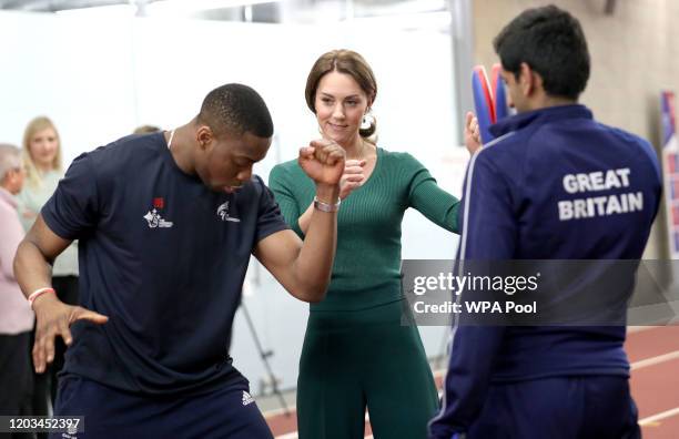 Catherine, Duchess of Cambridge is shown Taekwondo moves by Great Britain's Lutalo Muhammad during a SportsAid Stars event at the London Stadium in...