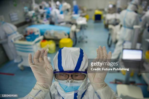 Male nurse Liu Hengming adjusts his goggles during working in the intensive care unit of a hospital designated for COVID-19 patients in Wuhan in...