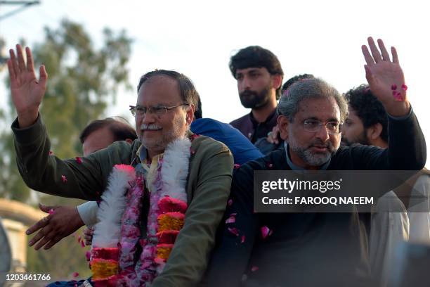 Pakistan's former prime minister Shahid Khaqan Abbasi , flanked by the former interior minister and PML-N leader Ahsan Iqbal , wave to supporters...