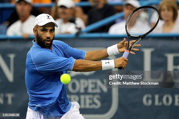 James Blake returns a shot to John Isner during the Legg Mason Tennis Classic presented by Geico at the William H.G. FitzGerald Tennis Center on...