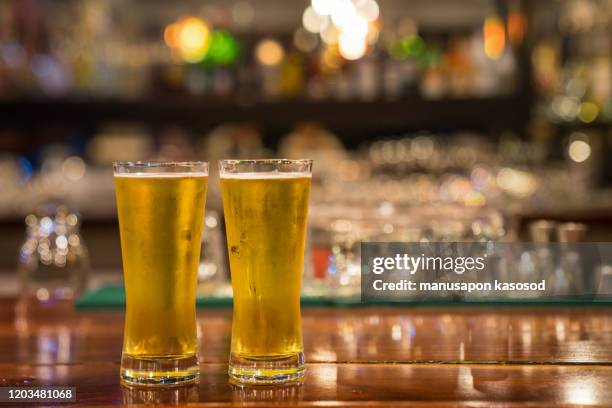 glass of beer on the bar counter. - beer bar stock-fotos und bilder