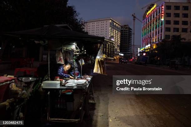 Cambodian woman cooks street food in Sihanoukville, Cambodia on February 15, 2020. Chinese are permanently changing the quiet oceanside resort....