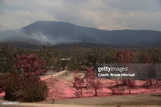 Fire retardant dropped from an air tanker is seen behind the Namadgi National Park Visitors centre February 02, 2020 in Canberra, Australia. A total...