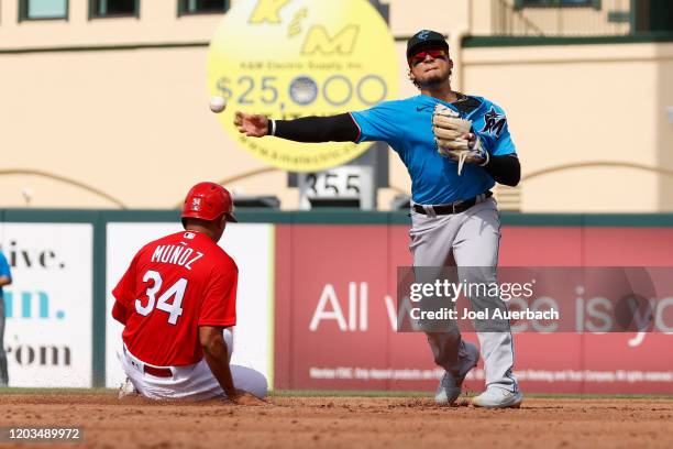 Isan Diaz of the Miami Marlins is unable to turn the double play getting Yairo Munoz the St Louis Cardinals out at second base during a spring...