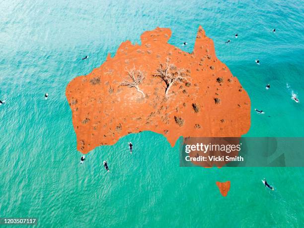 map of australia with red desert in the center and surfers in the ocean around the outside - australische kultur stock-fotos und bilder