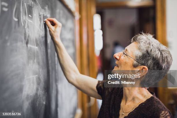 eureka! mathemathics professor at chalkboard writing formula solution - mathematician stock pictures, royalty-free photos & images
