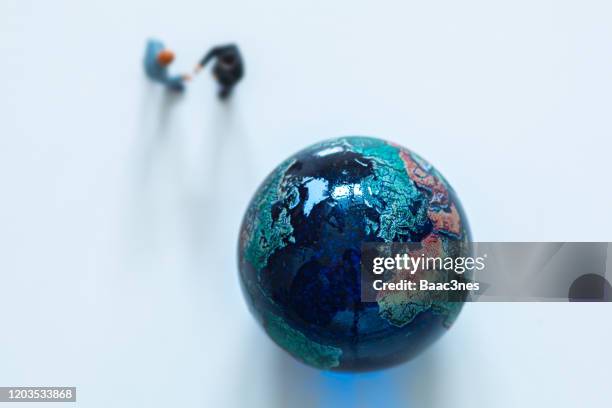 marble earth and two men shaking hands - culture change stock pictures, royalty-free photos & images