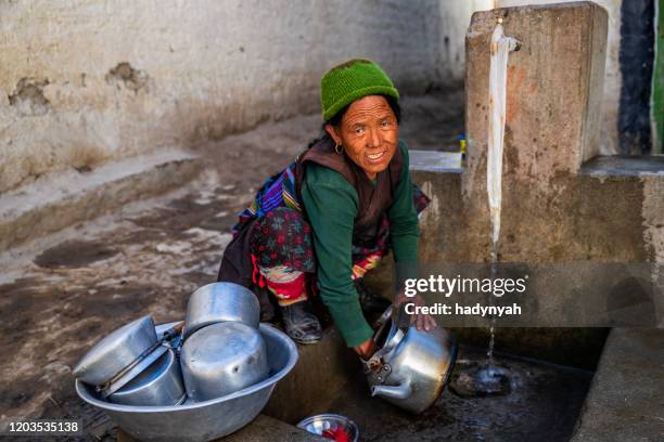 藏族婦女洗碗。野馬 - lo manthang 個照片及圖片檔