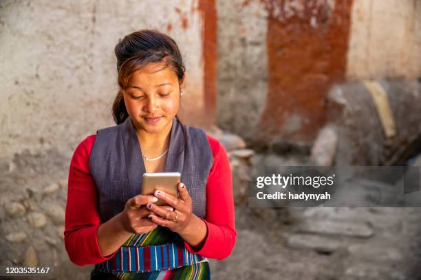 jovem tibetana usando celular, mustang superior, nepal - nepalese ethnicity - fotografias e filmes do acervo