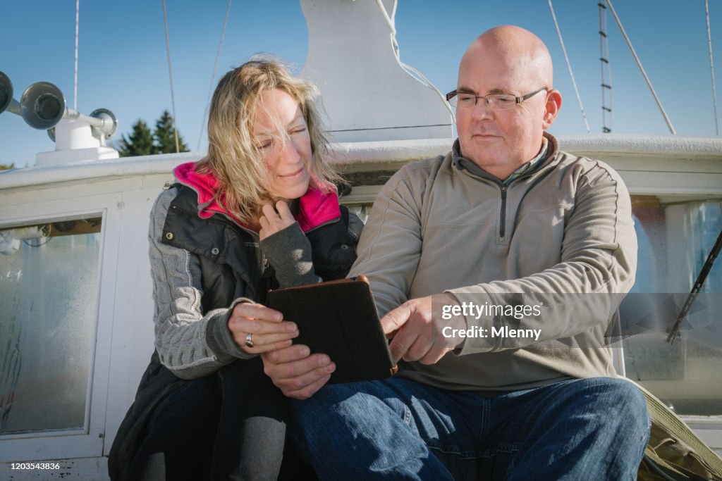 Hoger Paar dat digitale TabletComputer op hun Zeilboot controleert