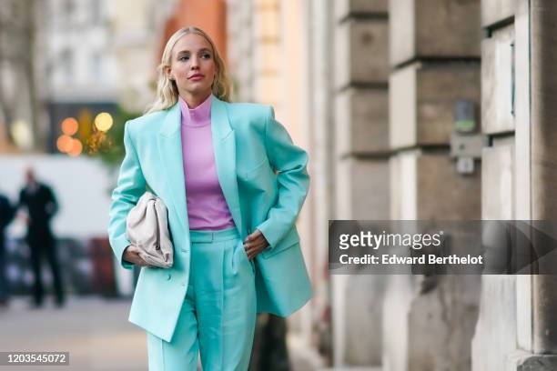 Leonie Hanne wears earrings, a mauve hi-neck top, a sea-green jacket, hot pink sandals, a cream-color quilted clutch, outside Ralph & Russo, during...