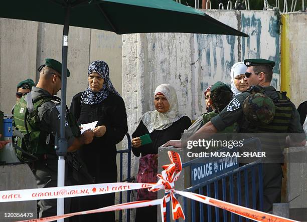 Muslim Palestinian women show their identity cards to Israeli security forces at a checkpoint on the outskirts of the West Bank city of Bethlehem, as...
