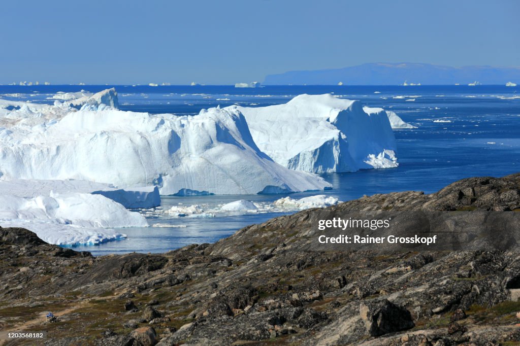 Elevated view from rocky terrain at huge icebergs