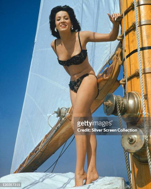 Linda Cristal, Argentinian actress, wearing a black bikini, standing on the deck of a yacht, circa 1965.