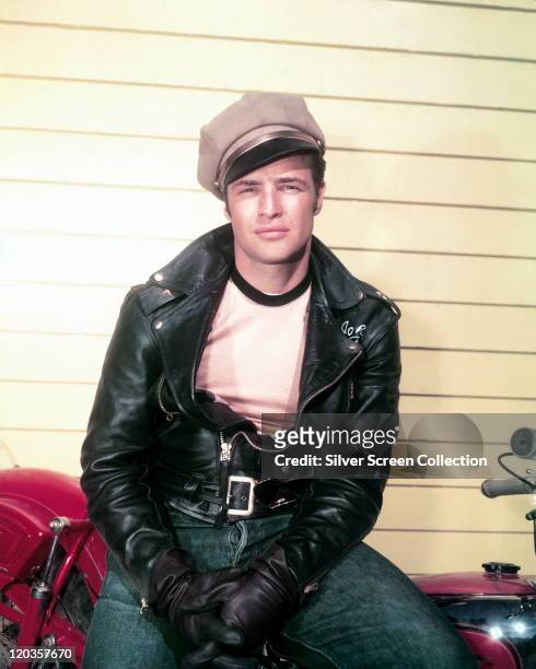 Marlon Brando , US actor, wearing a peaked cap and black leather jacket and gloves in a publicity portrait issued for the film, 'The Wild One', USA,...
