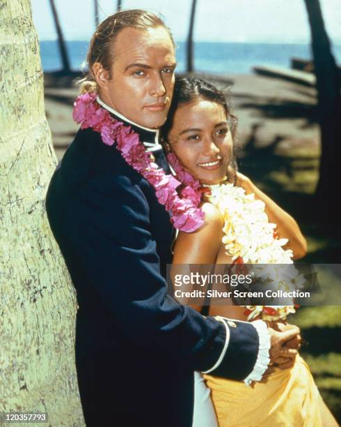 Marlon Brando , US actor, with Tarita Teriipia, French Polynesian actress, both wearing floral garlands in a publicity portrait issued for the film,...